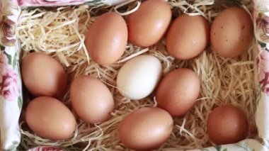 Fresh raw eggs in a wicker square filled basket, top view. Natural, healthy farm food. Village products