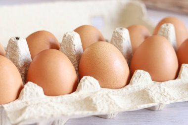 Eggs in a cardboard box. Fresh raw eggs in a paper egg container. Open egg packaging, close-up. Fresh protein food