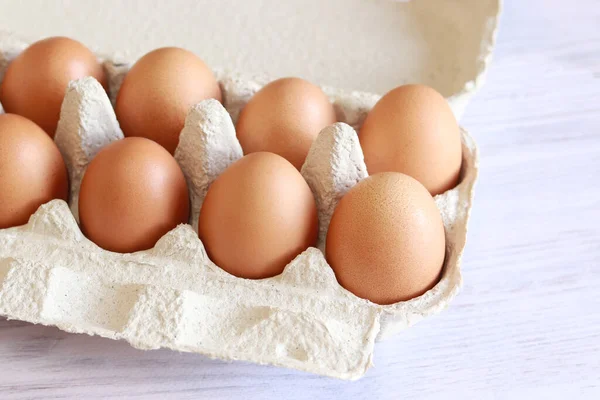 Eggs in a cardboard box. Fresh raw eggs in a paper egg container. Open egg packaging, close-up. Fresh protein food.