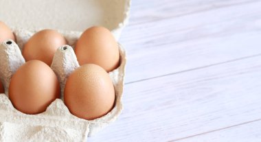 Karton kutuda yumurtalar. Kağıt yumurta kabında taze çiğ yumurta. Yumurta ambalajını aç, yakın plan. Taze protein yiyeceği.