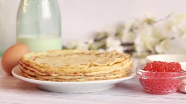 Preparation of thin pancakes, still life. Put the pancake on the stack. Breakfast in a cozy kitchen