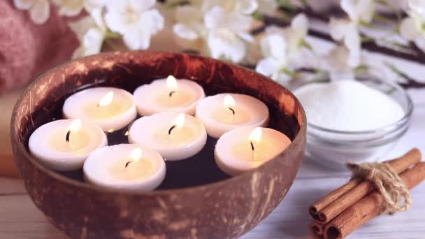Spa Komposition Nahaufnahme Brennende Kerzen Wasser Kokosnussschale Mit Kerzen Blumen — Stockvideo