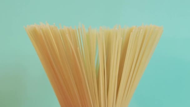 Een Pakje Ongekookte Spaghetti Draait Rond Een Blauwe Achtergrond Side — Stockvideo