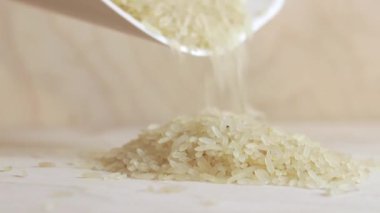 Pirinci bir yığın halinde yüzeye dökün. Pirinç uzun haşlanmış cilalanmış. Pirinç taneleri masaya düşer. Harika.