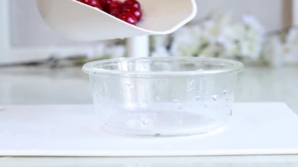 冰冻的樱桃 将塑料勺中冰冻的樱桃倒入玻璃器皿中 馅饼或蛋糕 烹调准备 解冻的浆果 — 图库视频影像