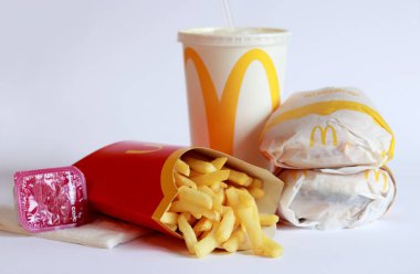 Kyiv, Ukrayna - 18 Mart 2023: Beyaz arka planda McDonald 's yemeği. McDonald 's Corporation dünyanın en büyük fast food restoranıdır. Satrançlı burger, patates kızartması, hardal ve içecek.