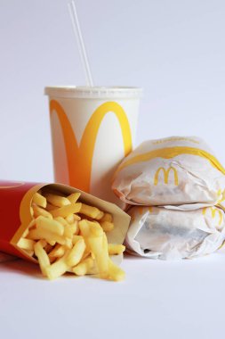 Kyiv, Ukrayna - 18 Mart 2023: Beyaz arka planda McDonald 's yemeği. McDonald 's Corporation dünyanın en büyük fast food restoranıdır. Satranç hamburgeri, patates kızartması ve içki.