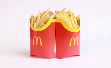 Kyiv, Ukrayna - 22 Mart 2023: Hafif arka planda iki büyük porsiyon patates kızartması, yazı için boş alan. McDonald 's Corporation dünyanın en büyük fast food restoranıdır. Hafif arka planda patates kızartması.