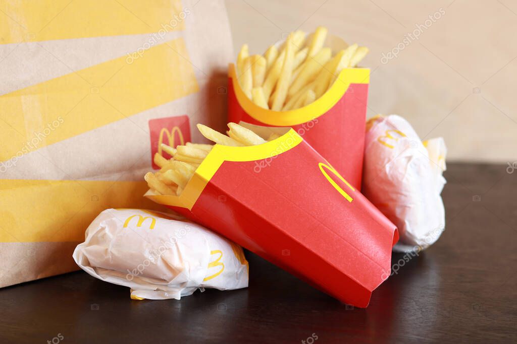 Kyiv, Ukraine - March 22, 2023: Two packs of french fries, cheeseburgers and a large paper bag. Fast food. McDonald's Corporation is the world's largest fast food restaurant
