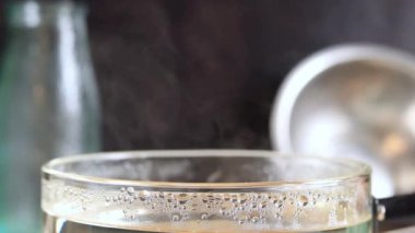 Demlikten buhar çıkıyor. Tencereyi kaynar suyla kapat, sıcak yemek. Cam bir tavadan aktif buhar. Yemek pişirmek.