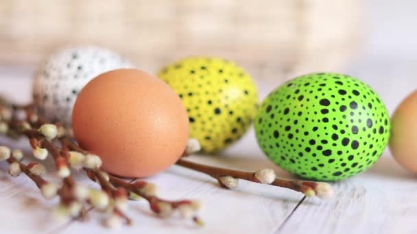 复活节彩蛋在木制桌子和柳条上的特写 彩绘复活节彩蛋是宗教节日的传统象征 基督教庆祝传统 — 图库视频影像