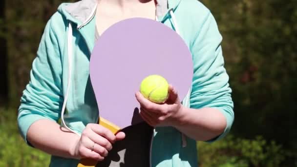 一个拿着木制网球拍和球的女孩 — 图库视频影像