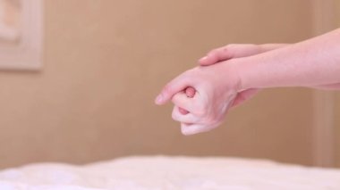 Yatak odasında bir sabah, beyaz bir battaniyenin altında kadın bacakları. Sağlıklı uyku rahatlığı, tembel sabah konsepti. Otel konseptinde dinlenmek. Yatakta beyaz çarşafların arkasından bakan bir kadının ayak parmakları.