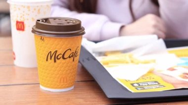 Kyiv, Ukrayna - 11 Mayıs 2023: Kız McDonalds 'da açık hava masasında yemek yiyor. Kız fast food yiyor. Kadın eli patates kızartması alır. McDonald 's Şirketi
