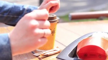 Kyiv, Ukrayna - 11 Mayıs 2023: McDonalds Restaurant 'ta McCafe sarı kapuçino kahvesi. Kahve fincanının kapağını aç. McDonald 's' da kahve. Açık hava masasında yemek. Seçici odak