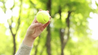 Parkta aktif oyunlar oynayın. Tahta bir raketle topa vur. Tenis raketiyle kadın eli, yakın plan. İyi havalarda hobiler ve dinlenme. Açık hava spor aktivitesi