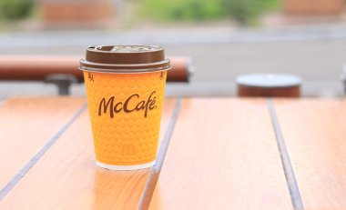 Kyiv, Ukrayna - 11 Mayıs 2023: McDonalds restoranında sarı McCafe bardağı kapuçino. Dışarıda latte içeriz. Kahveli kâğıt bardak.