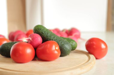 Masada taze sebzeler, seçici bir odak noktası. Domates, salatalık ve turp. Salata için sebze. Salata yapmak için çeşitli taze malzemeler. Sağlıklı gıda konsepti. Yakın plan.