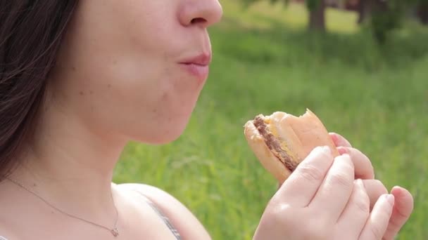Haar Gezicht Eet Een Cheeseburger Natuur Hongerige Jonge Vrouw Die — Stockvideo