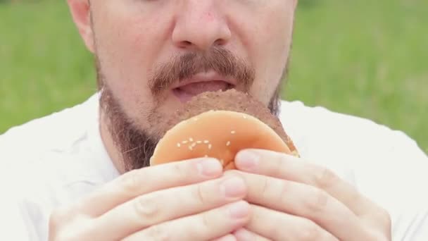Eet Een Hamburger Een Close Mannelijk Gezicht Die Een Grote — Stockvideo