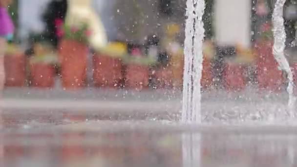 歩行者噴水のクローズアップ 夏に乾燥した噴水 水が飛び散り 背景がぼやけています ドライデッキ市内の噴水 地上からの眺め — ストック動画