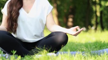 Bahar ya da yaz aylarında açık havada meditasyon. Spor ya da eğlence. Nilüfer pozisyonunda yoga minderinde meditasyon pozu veren bir kız. Güneşli bir günde yoga çalışıyorum.