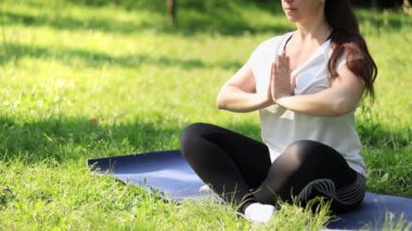 Bahar ya da yaz aylarında açık havada meditasyon. Spor ya da eğlence. Nilüfer pozisyonunda yoga minderinde meditasyon pozu veren bir kız. Güneşli bir günde yoga çalışıyorum.