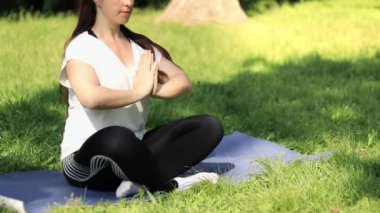 Bahar ya da yaz aylarında açık havada meditasyon. Spor ya da eğlence. Nilüfer pozisyonunda yoga minderinde meditasyon pozu veren bir kız. Güneşli bir günde yoga çalışıyorum.