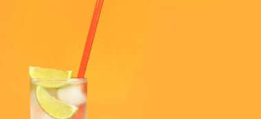 Turuncu arka planda buzlu ve limonlu buzlu çay. Soğuk içecekle yaz kokteyli. Boşluğu kopyala