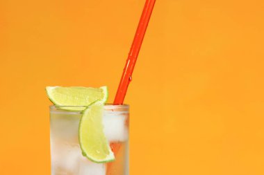 Turuncu arka planda buzlu ve limonlu buzlu çay. Soğuk içecekle yaz kokteyli. Boşluğu kopyala