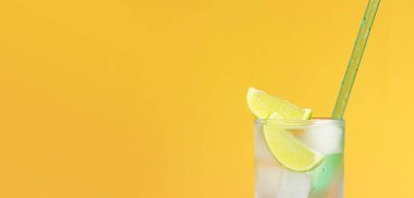 Parlak turuncu arka planda buzlu ve limonlu limonata. Soğuk içecekle yaz kokteyli. Uzayı kopyala Kamışla yakın plan iç.