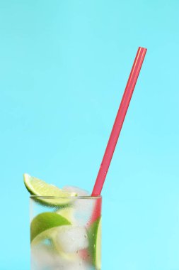 Açık mavi arka planda buzlu ve limonlu limonata. Soğuk içecekle yaz kokteyli. kopyalama alanı. Kamışla yakın plan iç.