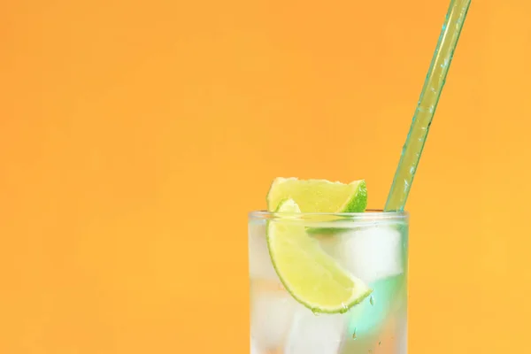 stock image Lemonade with ice and lime on a bright orange background. Summer cocktail with cold drink. Copy space. Drink with a straw close-up