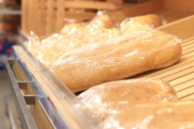 Raftaki bir dükkanda bir paket ekmek. Baton yakın çekim. Süpermarkette ekmek.