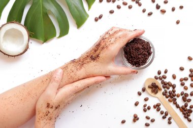 Doğal ev yapımı kahve fırçalı kadın elleri beyaz arka planda, malzemeler yakında, üst tarafta. Spa tedavisi. Spa kişisel bakım konsepti. Düz konum
