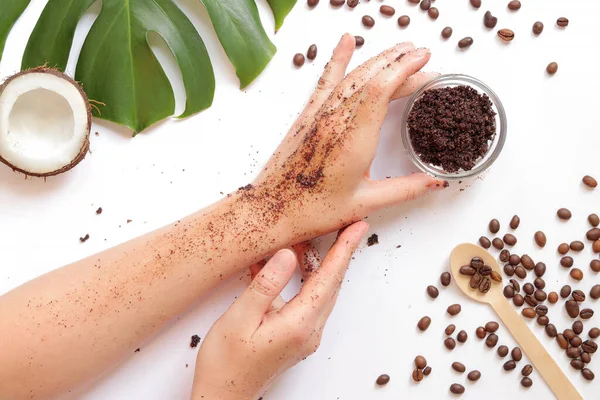 Female hands with natural homemade coffee scrub on a white background, ingredients nearby, top view. Spa treatment. Spa self care concept. Flat lay composition