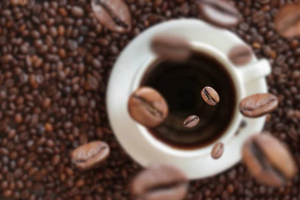 Kaffeebohnen Fallen Eine Tasse Kaffee Weiße Tasse Mit Kaffee Auf — Stockfoto