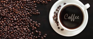 Kahve Americano. Kavrulmuş kahve çekirdeğinin arka planında bir fincan kahvenin en üst görüntüsü. Beyaz bardakta kahve içmek. Pankart