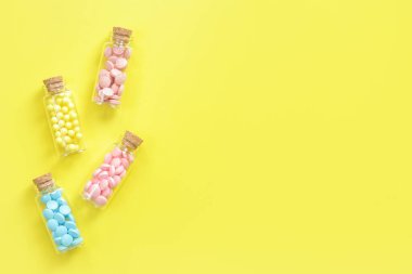 Vitaminler cam şişelerde, sarı arka planda, üst tarafta. Metin için yer, kopyalama alanı. Vitaminler, ağrı kesiciler, sağlık ilaçları ve diyet takviyeleri.