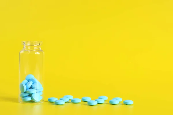 Pillole Blu Vengono Versate Una Bottiglia Vetro Uno Sfondo Giallo — Foto Stock