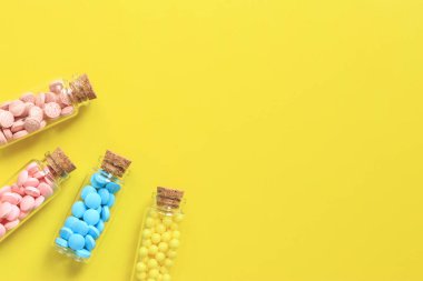Vitaminler cam şişelerde, sarı arka planda, üst tarafta. Metin için yer, kopyalama alanı. Vitaminler, ağrı kesiciler, sağlık ilaçları ve diyet takviyeleri.