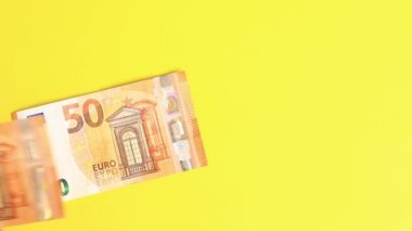 Hesaplamalar yap. Sarı arka planda 50 avroluk banknotlar çiz. Parlak bir geçmişe para yatırıyorum. Yatırım, iş, para değişimi veya ödeme kavramı