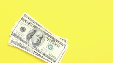 Hesaplamalar yap. Sarı arka plana 100 dolarlık banknotlar koyun. Parlak bir geçmişe para yatırıyorum. Yatırım, iş, para değişimi veya ödeme kavramı
