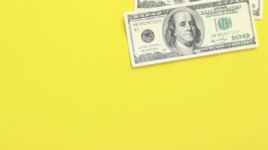 Hesaplamalar yap. Sarı arka plana 100 dolarlık banknotlar koyun. Parlak bir geçmişe para yatırıyorum. Yatırım, iş, para değişimi veya ödeme kavramı