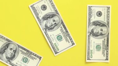 Hesaplamalar yap. Sarı arka plana 100 dolarlık banknotlar koyun. Parlak bir geçmişe para yatırıyorum. Yatırım, iş, para değişimi veya ödeme kavramı