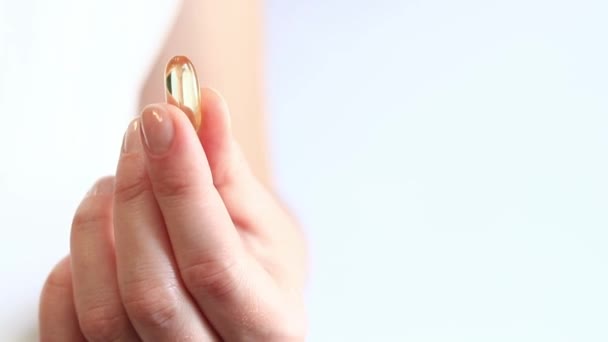 Κάψουλα Φαρμάκων Γυναικεία Χέρια Ωμέγα Φωτεινές Κίτρινες Διαφανείς Βιταμίνες Λευκό — Αρχείο Βίντεο