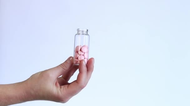 Różowe Tabletki Szklanej Butelce Witaminy Kobiecej Dłoni Białym Tle Witaminy — Wideo stockowe