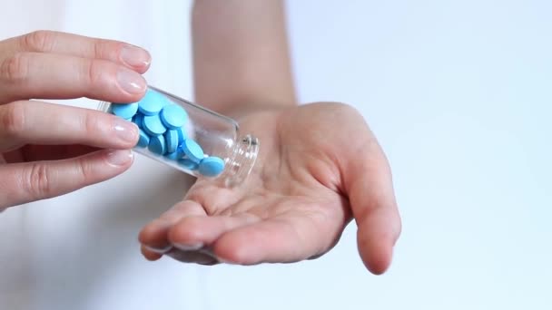 把药丸从玻璃瓶里倒进一个女人的手里 维生素和营养补充剂的特写 每天服用维生素 蓝色药丸 — 图库视频影像
