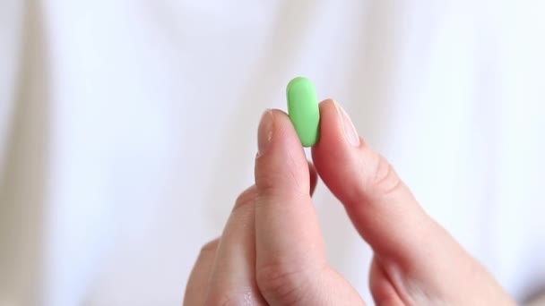 Витамины Белом Фоне Рука Держит Одну Зеленую Таблетку Двумя Пальцами — стоковое видео