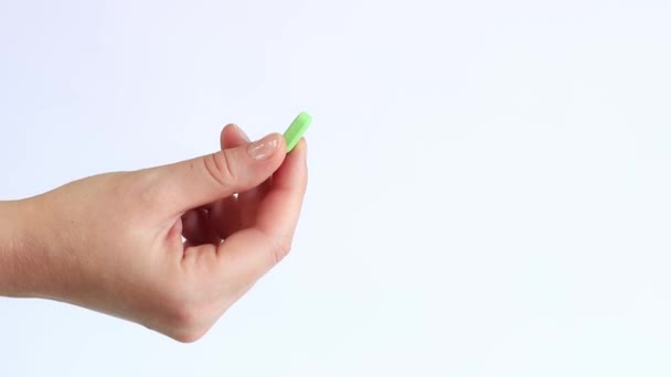 Mano Una Donna Tiene Una Pillola Verde Uno Sfondo Bianco — Video Stock